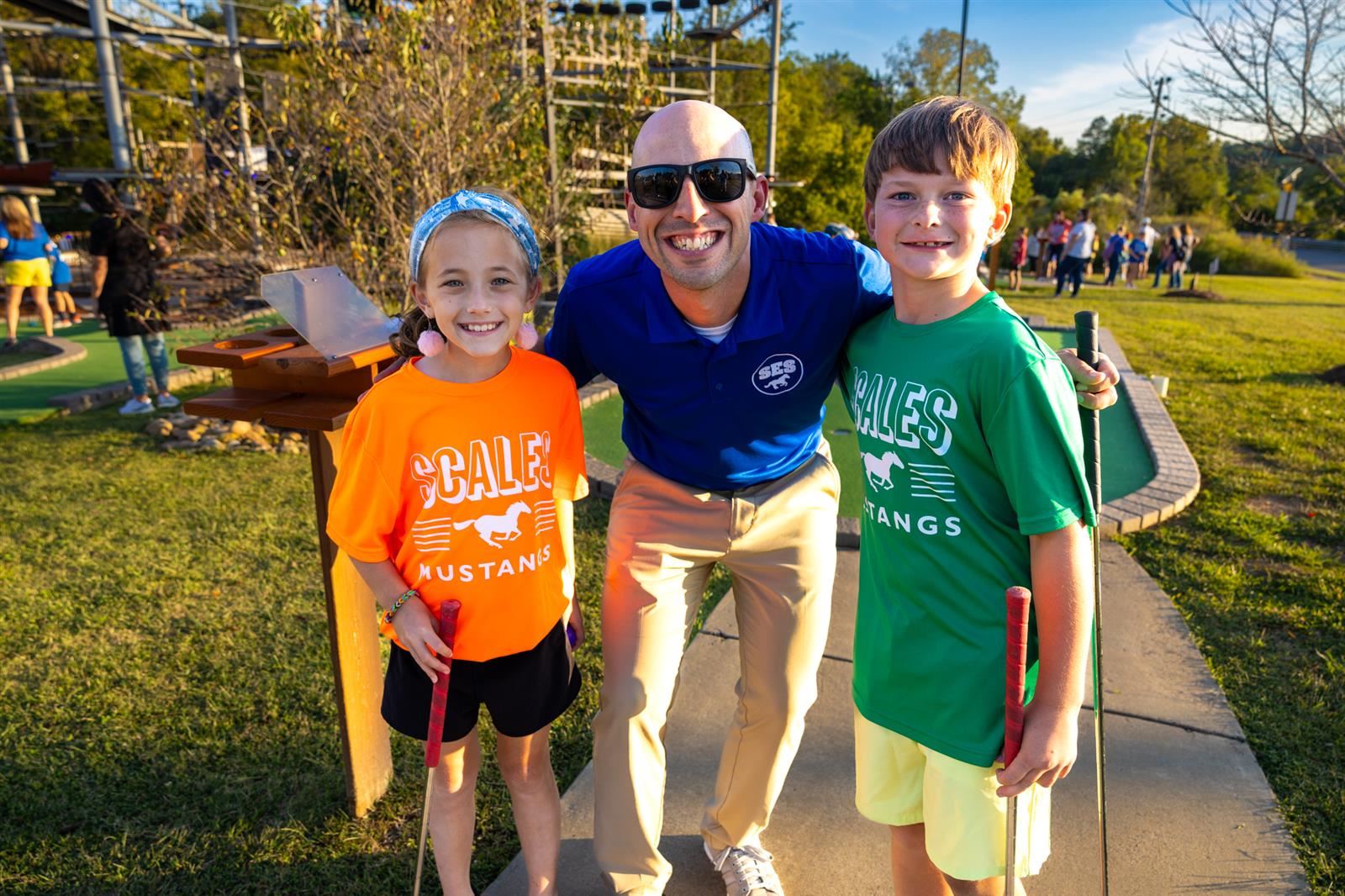 principal and two students at mini golf